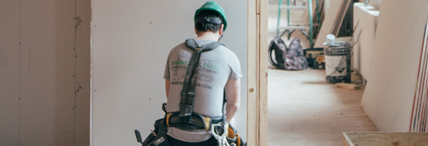 Ouvrier du bâtiment en cours d'installation d'un isolant phonique